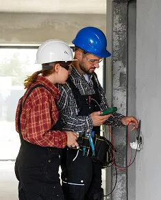 Two certified Fortify Services garage door technicians collaborating on-site during installation work