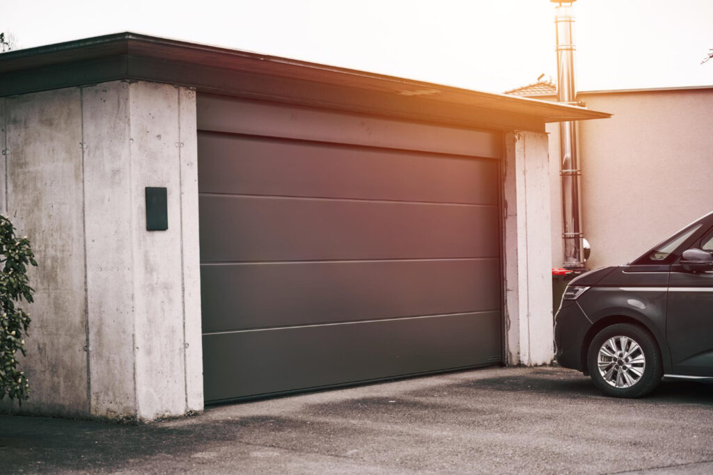 Professional garage door maintenance in Canadian home with technician inspecting steel door panels