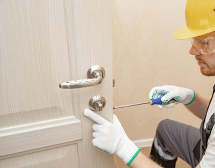 Locksmith fixing door lock in Ontario home — professional locksmith services