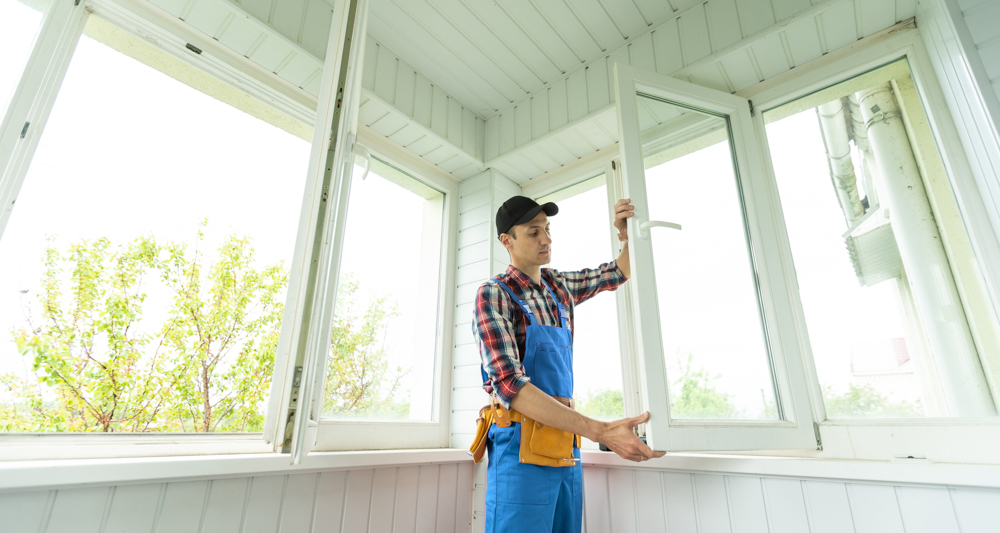 Professional technician installing glass balcony doors in Canadian home for energy efficiency and security
