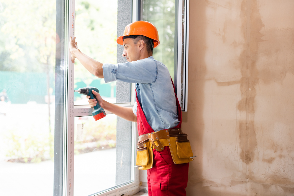 Technician installing energy-efficient window in Canadian home renovation project