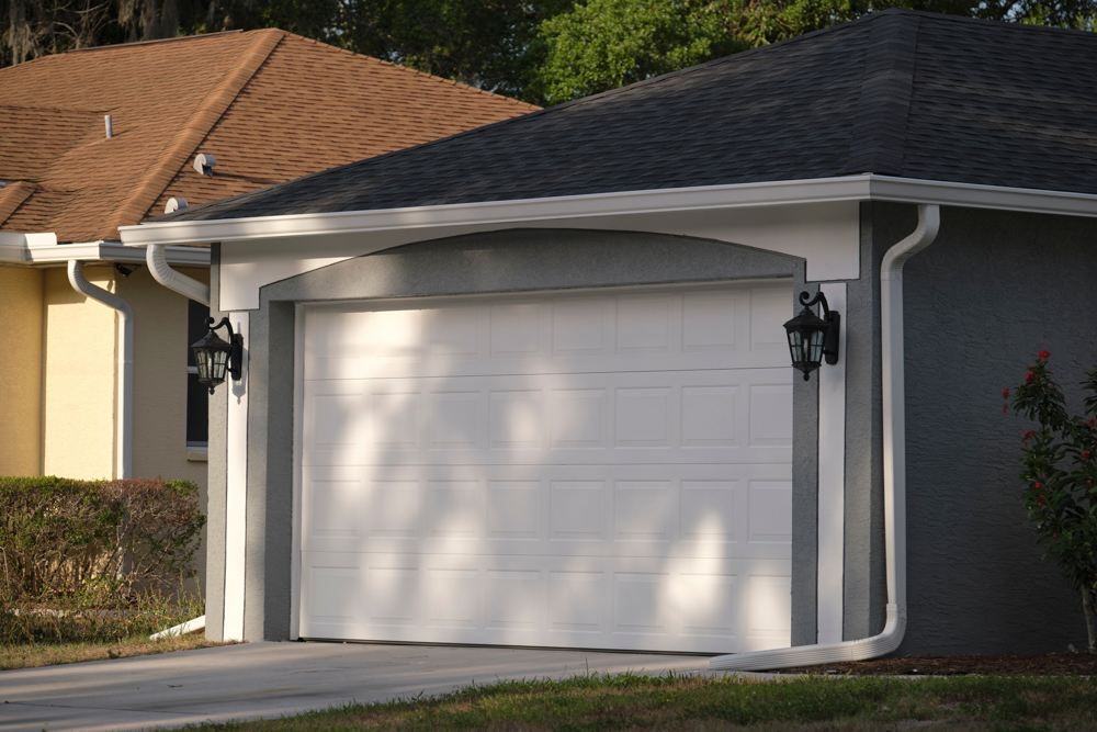 White sectional residential garage door on modern suburban home exterior