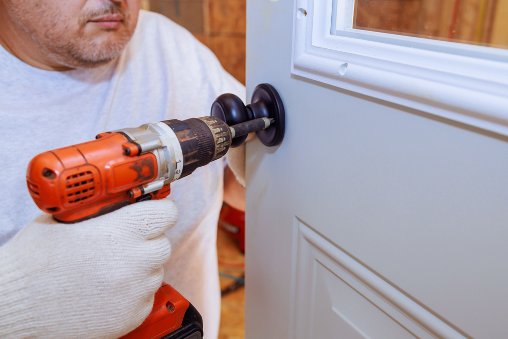 Certified locksmith installing front door lock in Canadian home