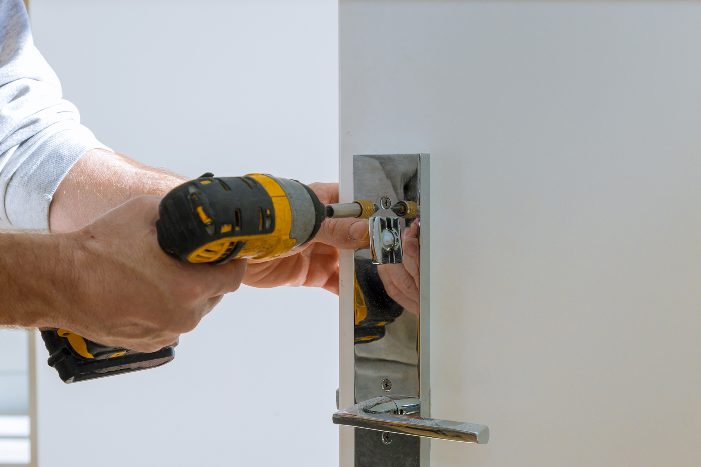 Lock installation on modern door with chrome handle