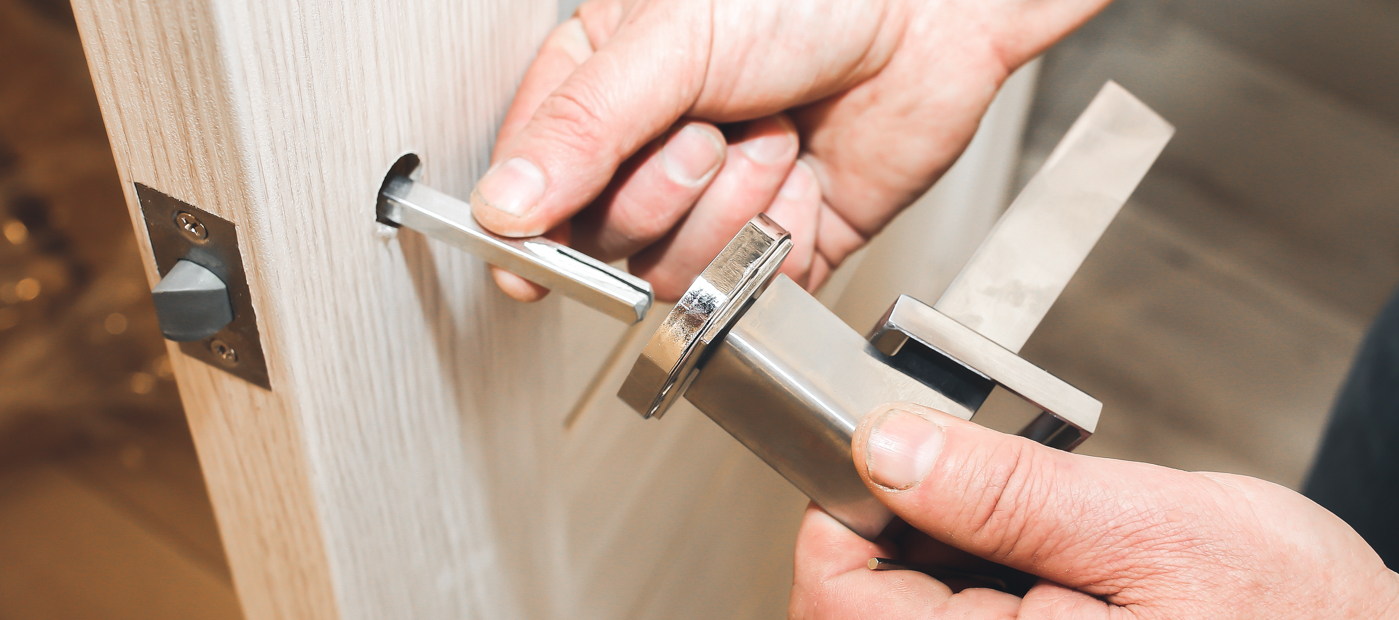 Lock installation on modern door with chrome handle