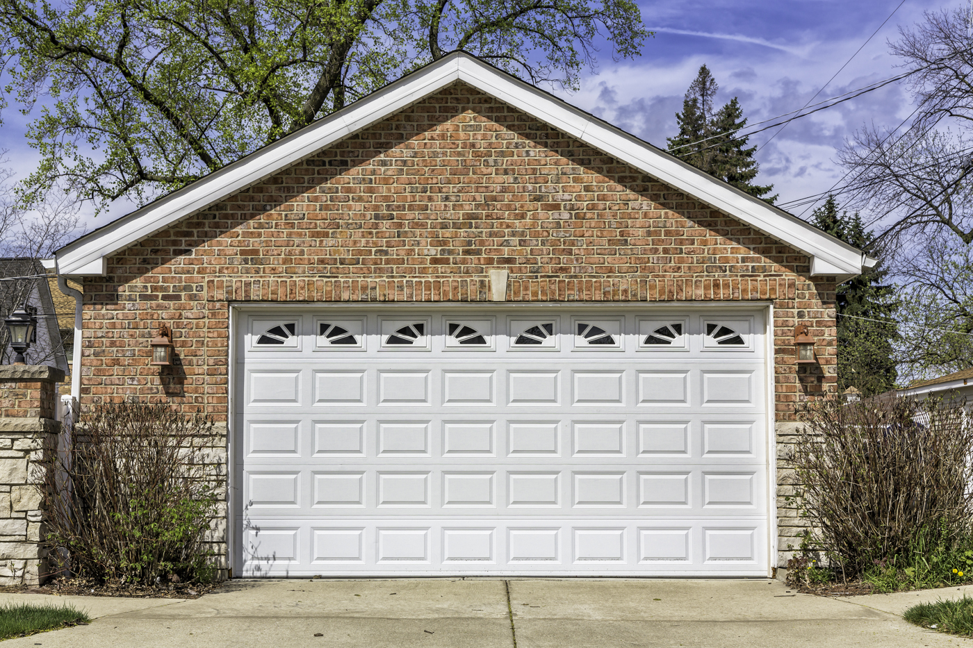 White residential garage door on brick Canadian home