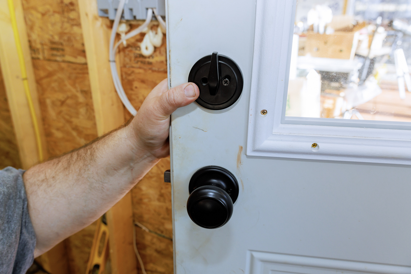 Locksmith installing door lock mechanism