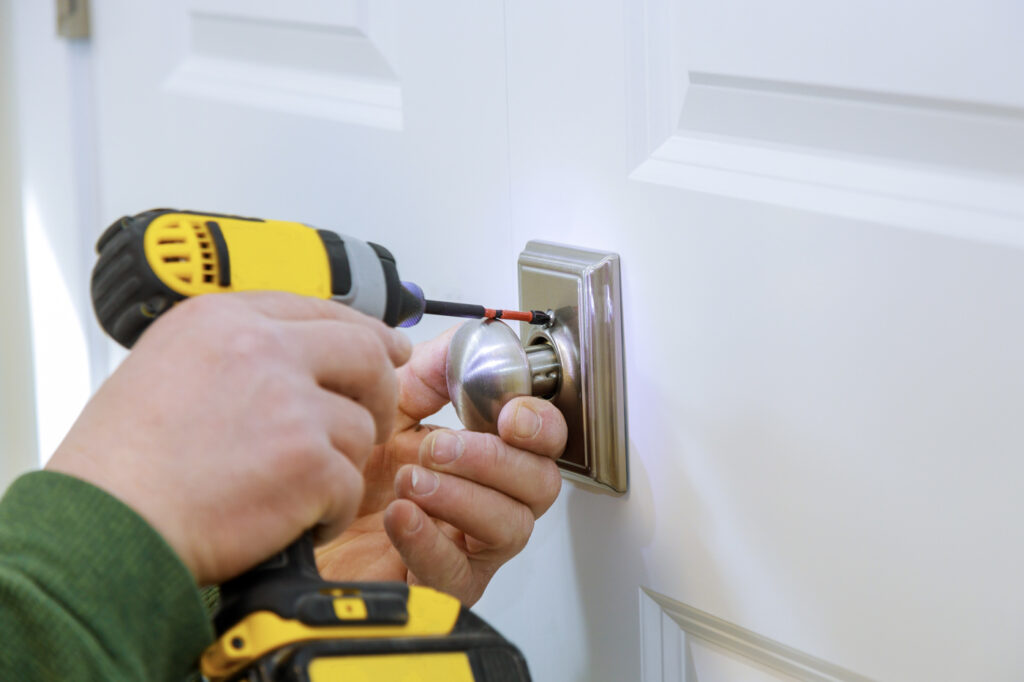 Locksmith installing door lock