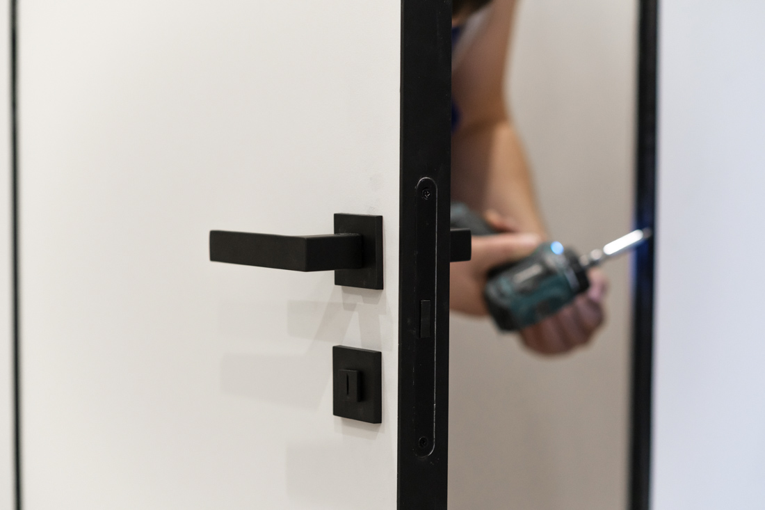 Locksmith installing door lock