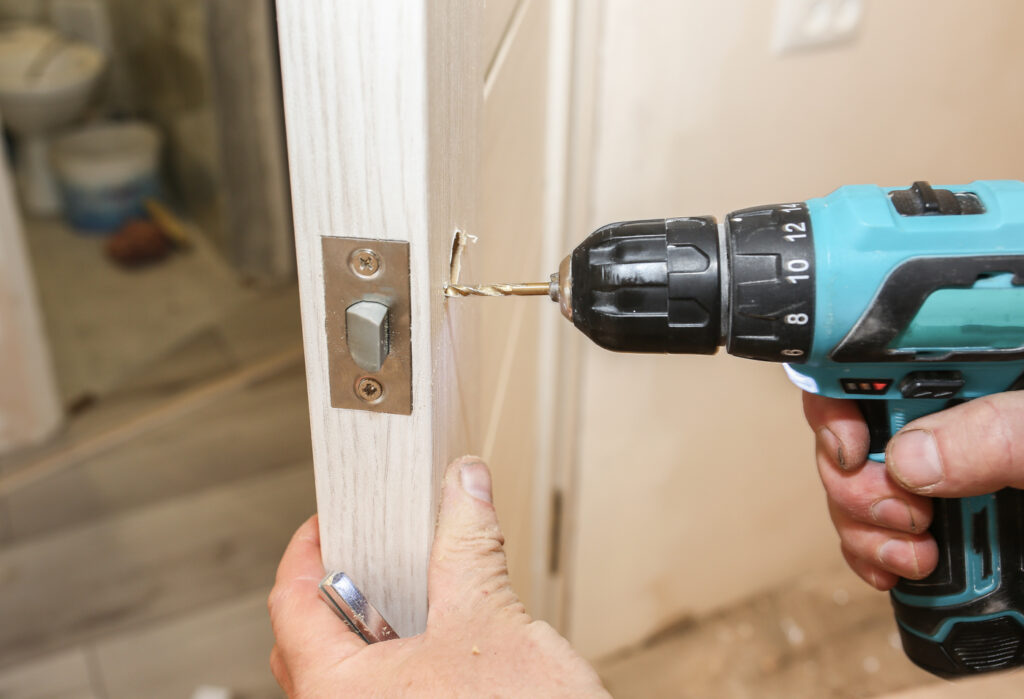 Locksmith drilling industrial door lock hole