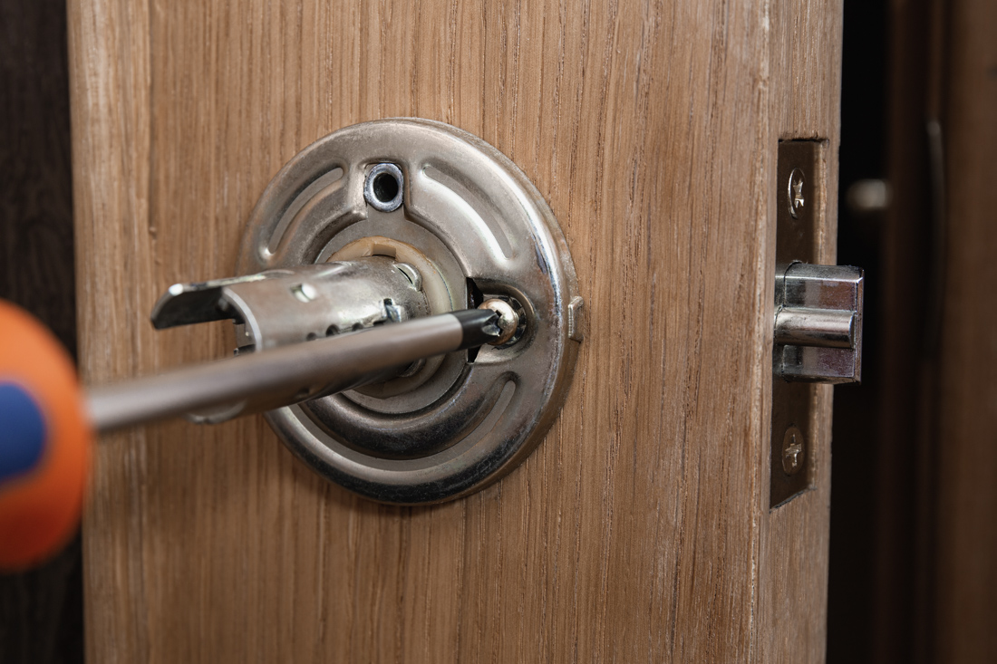 Insured locksmith repairing deadbolt lock