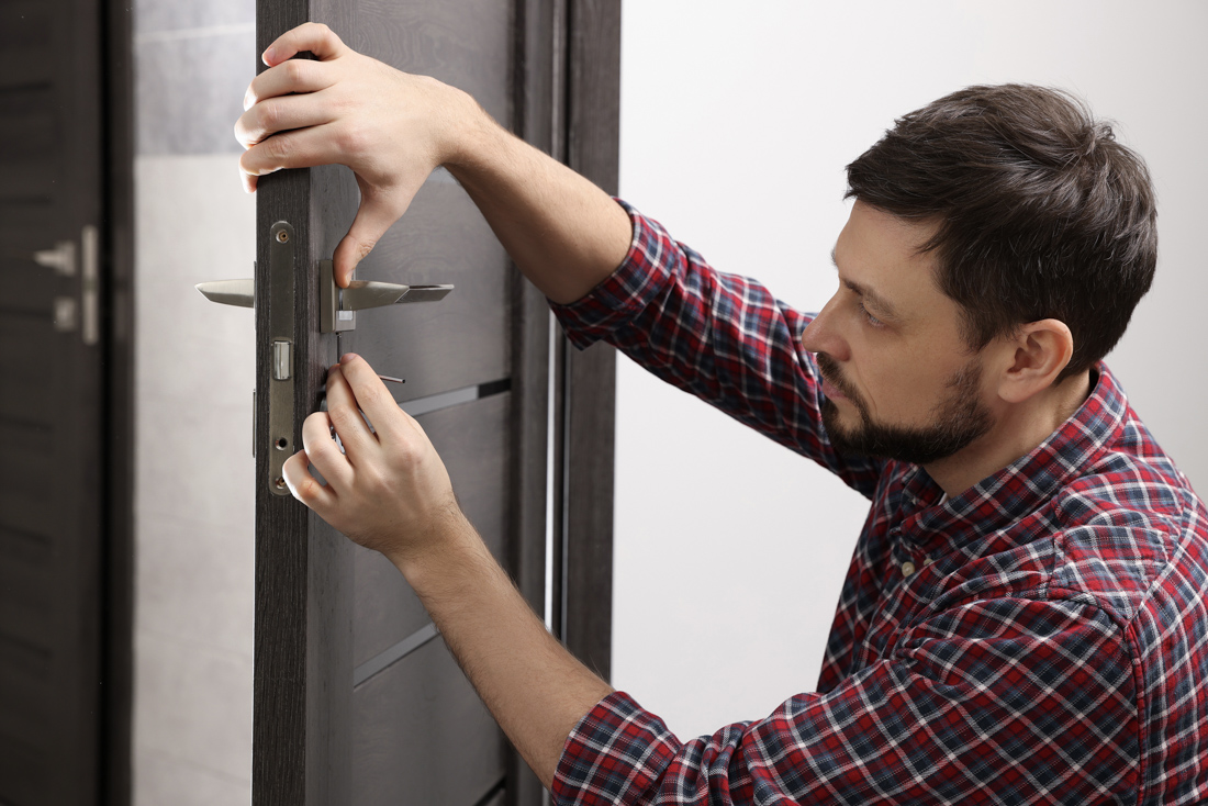 Locksmith performing door security assessment