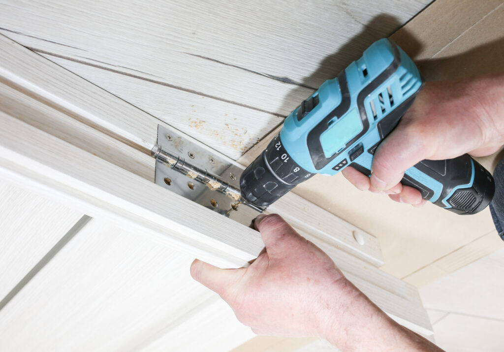 Door hinge repair with drill and wood trim