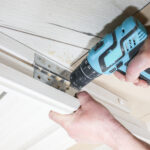 Door hinge repair with drill and wood trim